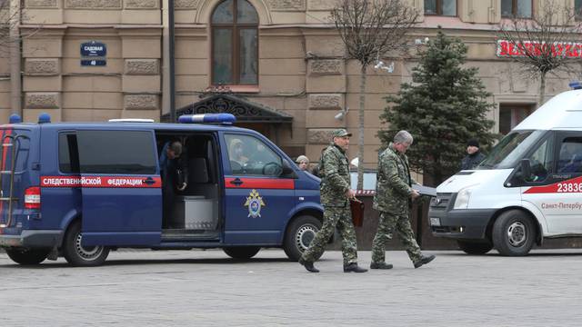 Members of security services walk past vehicle of Russia's Investigative Committee outside Sennaya Ploshchad metro station after explosion tore through train carriage in St. Petersburg metro system, in St. Petersburg