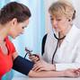 Taking blood pressure of female patient