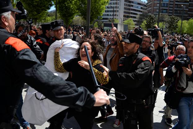 A protester breaks through a police line after a nine-year sentence was given to five men accused of the multiple rape of a woman during Pamplona