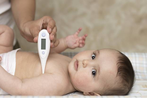 mother measures the temperature of a baby