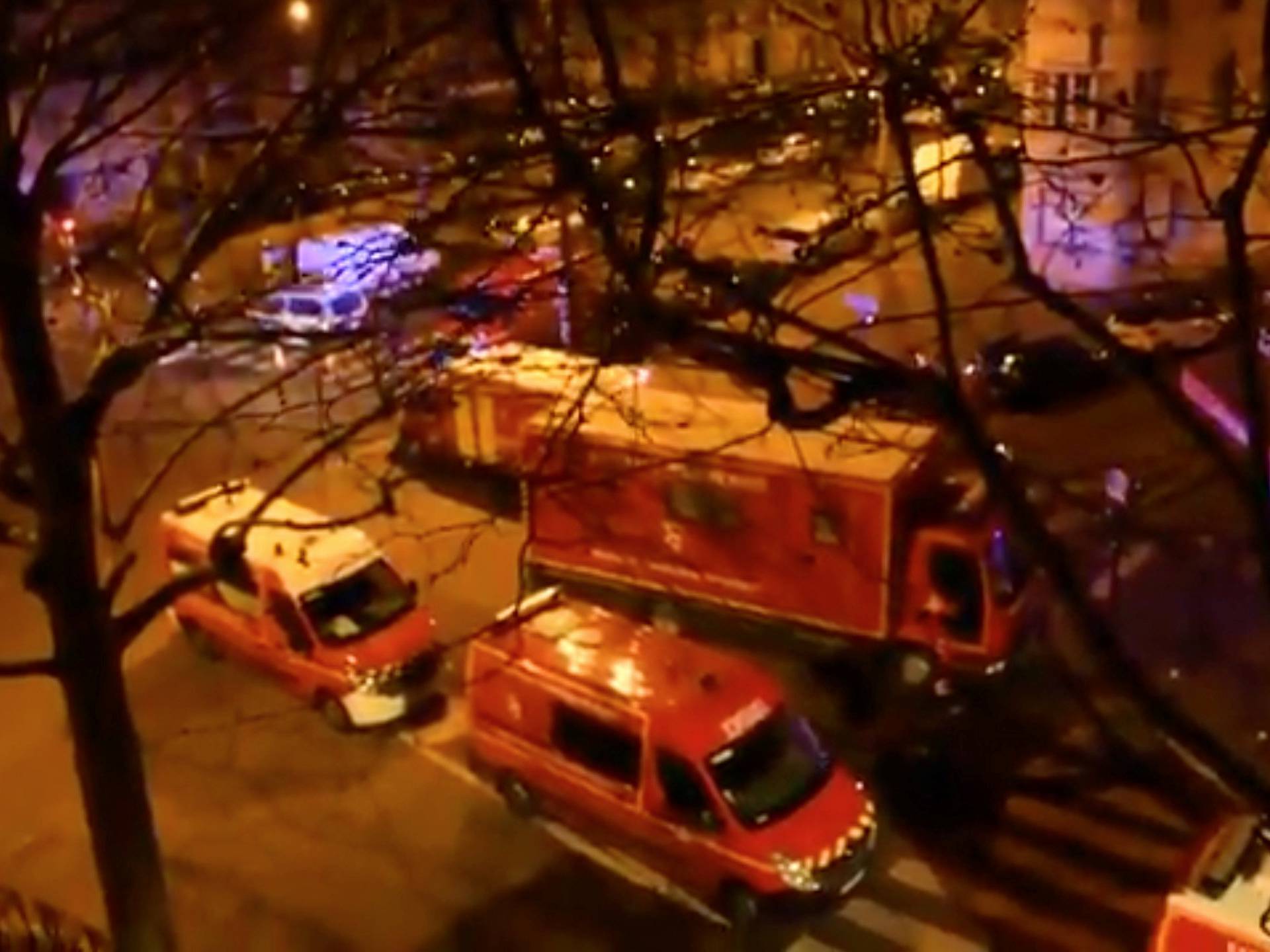 Emergency vehicles line a street where a residential building had caught fire in Paris