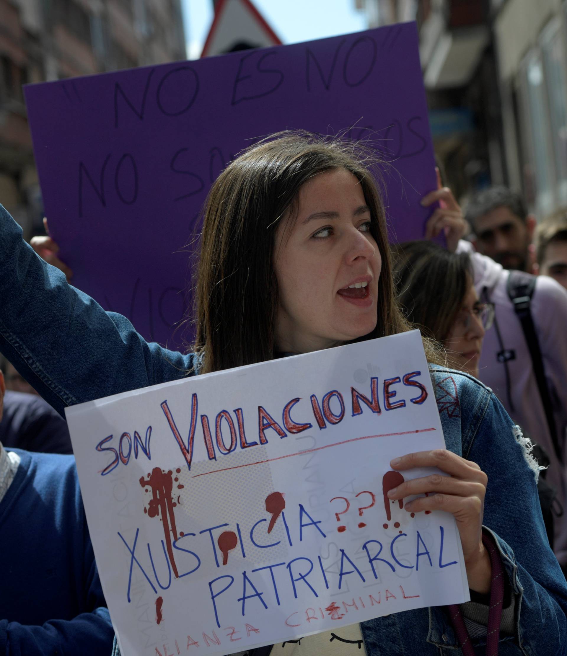 People shout slogans during a protest outside the courts in Aviles