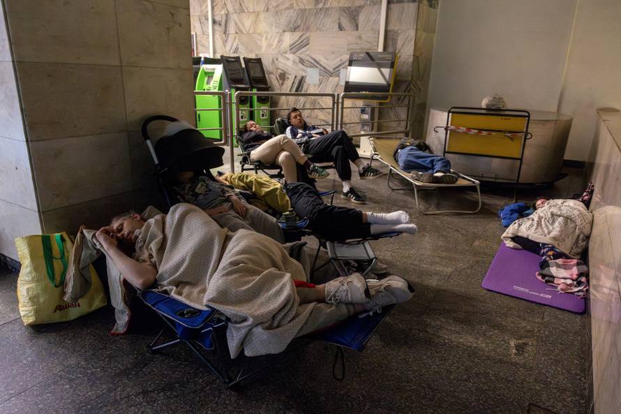 People take shelter in a metro station during Russian drone and missile strikes in Kyiv