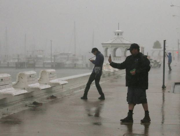 A storm chaser films himself on a camera phone as Hurricane Harvey approaches, on the boardwalk in Corpus Christi