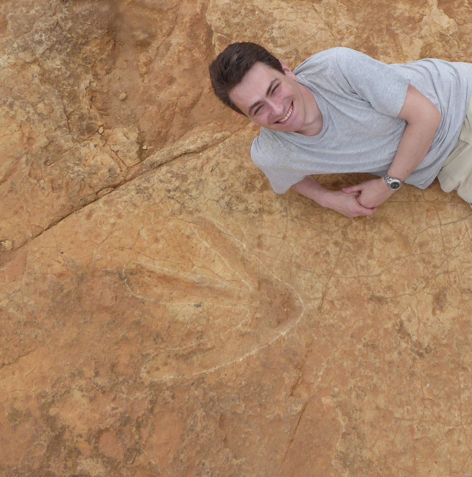 Fabien Knoll, Honorary Senior Research Fellow at the University of Manchester, lies next to the exceptionally large carnivorous dinosaur footprints found in Lesotho, Africa in this handout photo