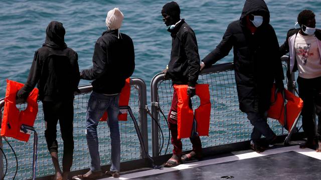 FILE PHOTO: Rescued migrants wait to disembark from an Armed Forces of Malta vessel in Senglea, in Valletta's Grand Harbour