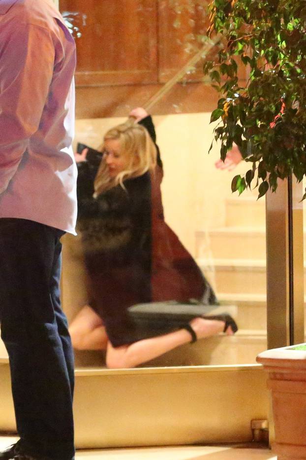 Reese Witherspoon takes a spill as she leaves the Sunset Tower Hotel after attending Jennifer Aniston