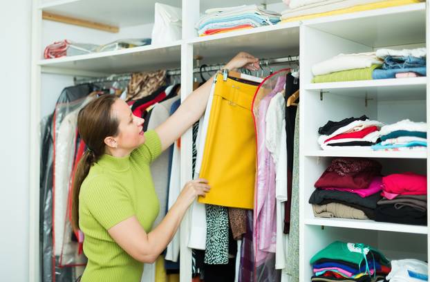 Woman arranging clothes at wardrobe