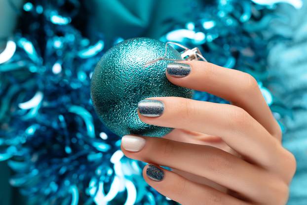 Beautiful female hand with blue christmas nail design