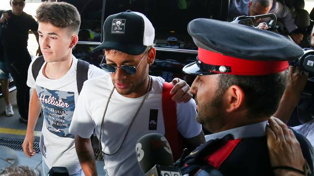 Brazilian soccer player Neymar walks in to a departure terminal at the airport in Barcelona