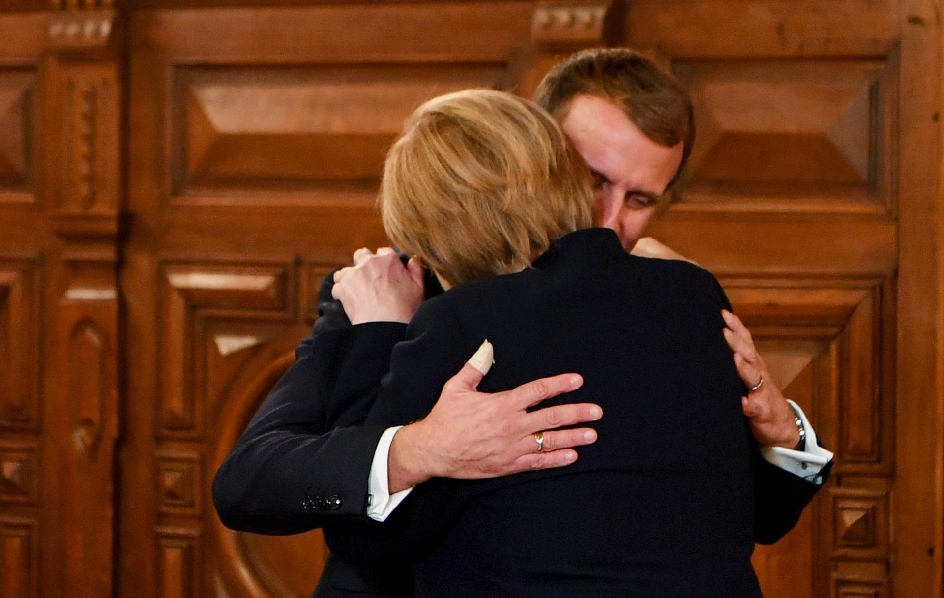 France's President Emmanuel Macron congratulates outgoing German Chancellor Angela Merkel during the ceremony of the Grand Cross, the highest distinction of the Legion d'Honneur, France's chief honour, in Beaune