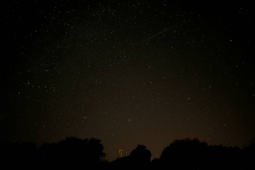 A meteor streaks past stars in the night sky during the annual Perseid meteor shower at a nature park and biosphere reserve near Malaga