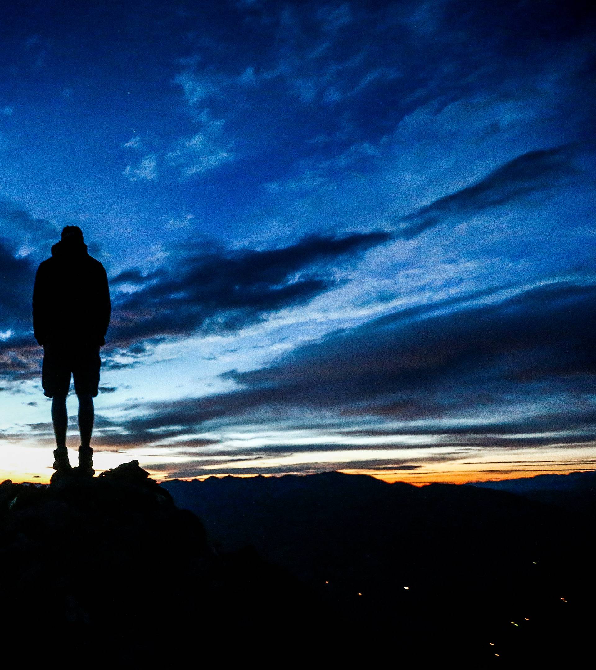 A man stands during sunrise on Kreuzjoch mountain in the Zillertal Alps in Schwendau