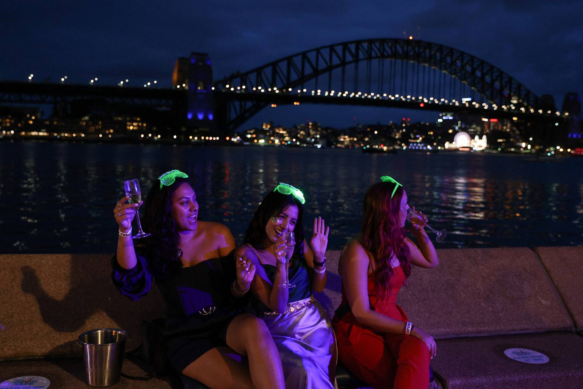 People begin celebrating New Year's Eve at the Sydney Harbour waterfront in Sydney