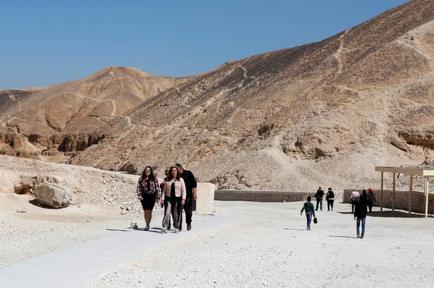 Tourists walk near the newly renovated tomb of boy pharaoh King Tutankhamun in Valley of the Kings in Luxor