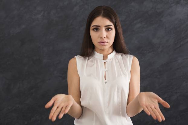 Desparate woman making helpless gesture with her hands