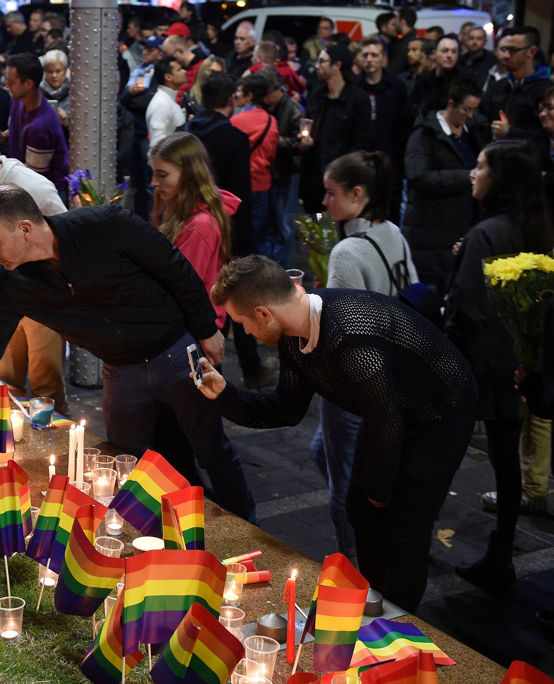 People gather at a vigil in solidarity for the victims of the Orlando nightclub mass shooting, at Taylor Square in Sydney