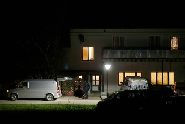 Coffins ans a hearse stand in front of a house where six people were found dead in Boeheimkirchen