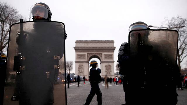 Riot police officers stand guard during a demonstration by the "yellow vests" movement on the Champs Elysees near the Arc de Triomphe in Paris