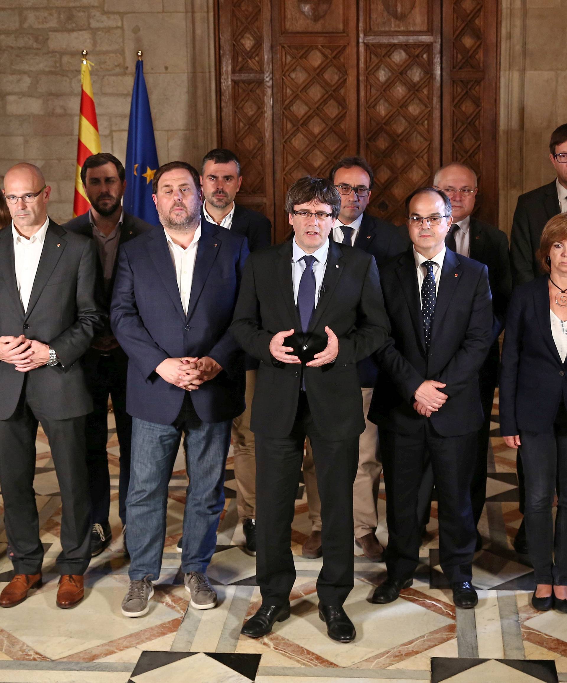 Catalan Regional President Puigdemont is flanked by members of his government as he makes a statement at Generalitat Palace in Barcelona