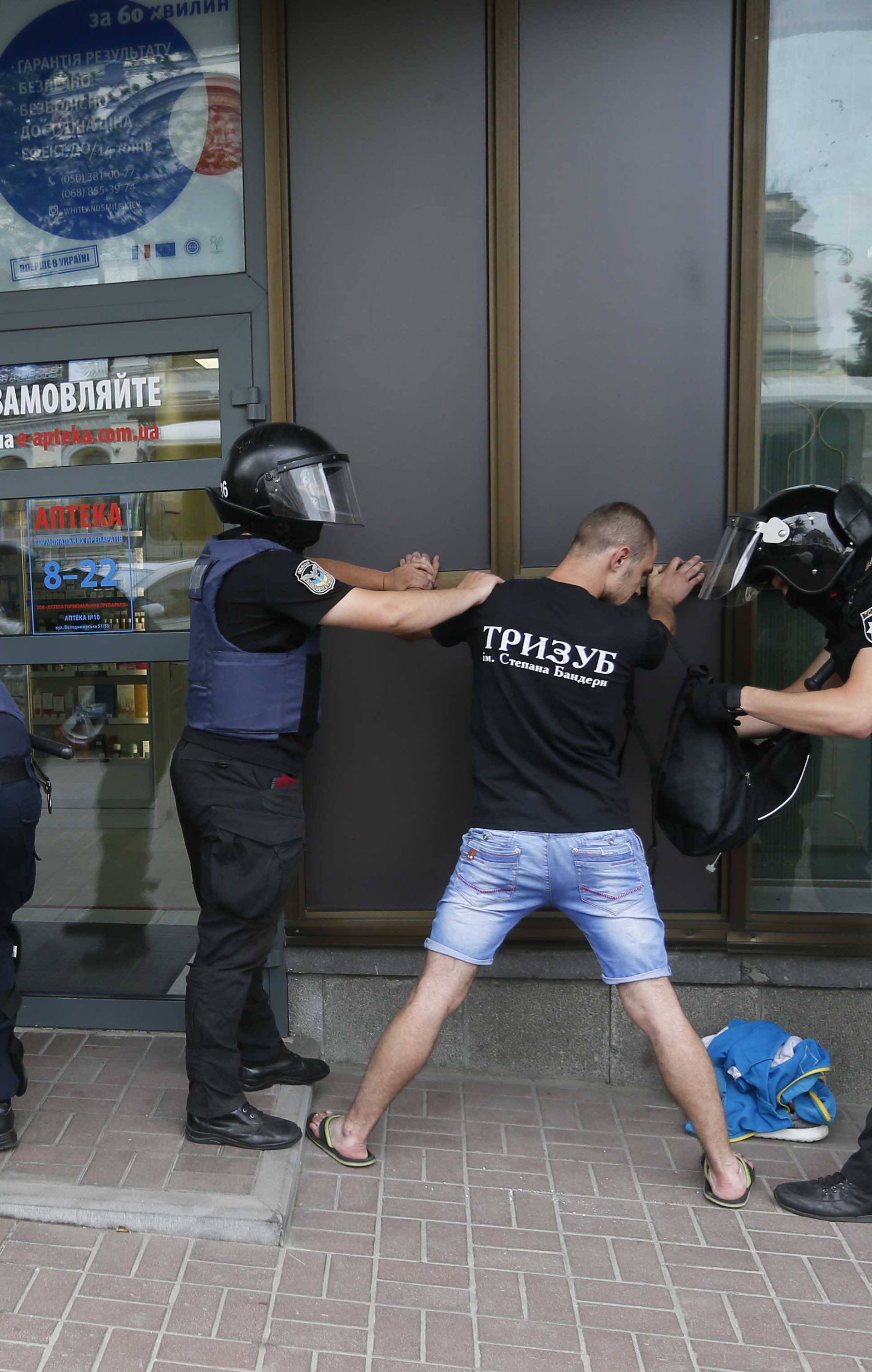 Riot police officers detain anti-LGBT protesters during the Equality March in Kiev