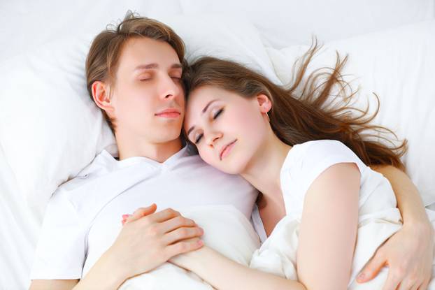 Happy couple  sleeping in bed at home