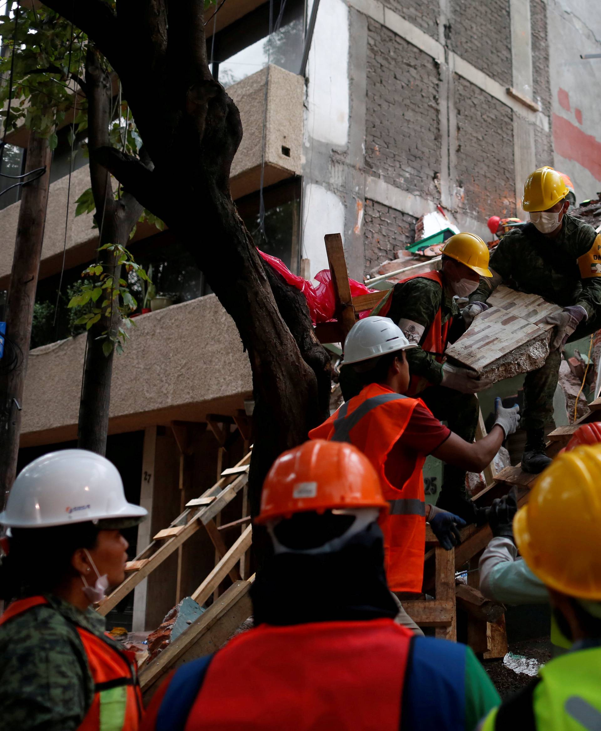 Mexican soldiers and rescue workers search for survivors in a collapsed building after an earthquake in Mexico City
