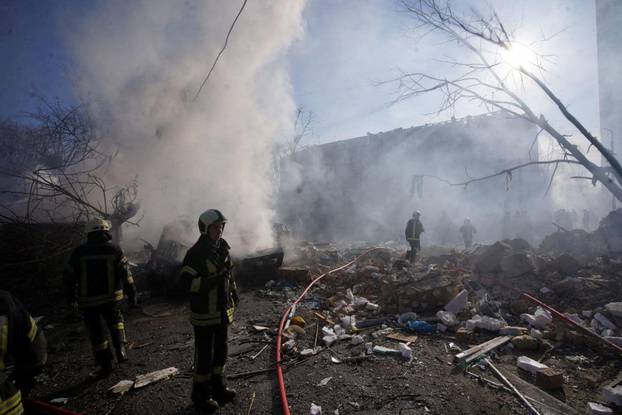 Ekipet e shpëtimit punojnë në një zonë të dëmtuar nga granatimet në Kiev