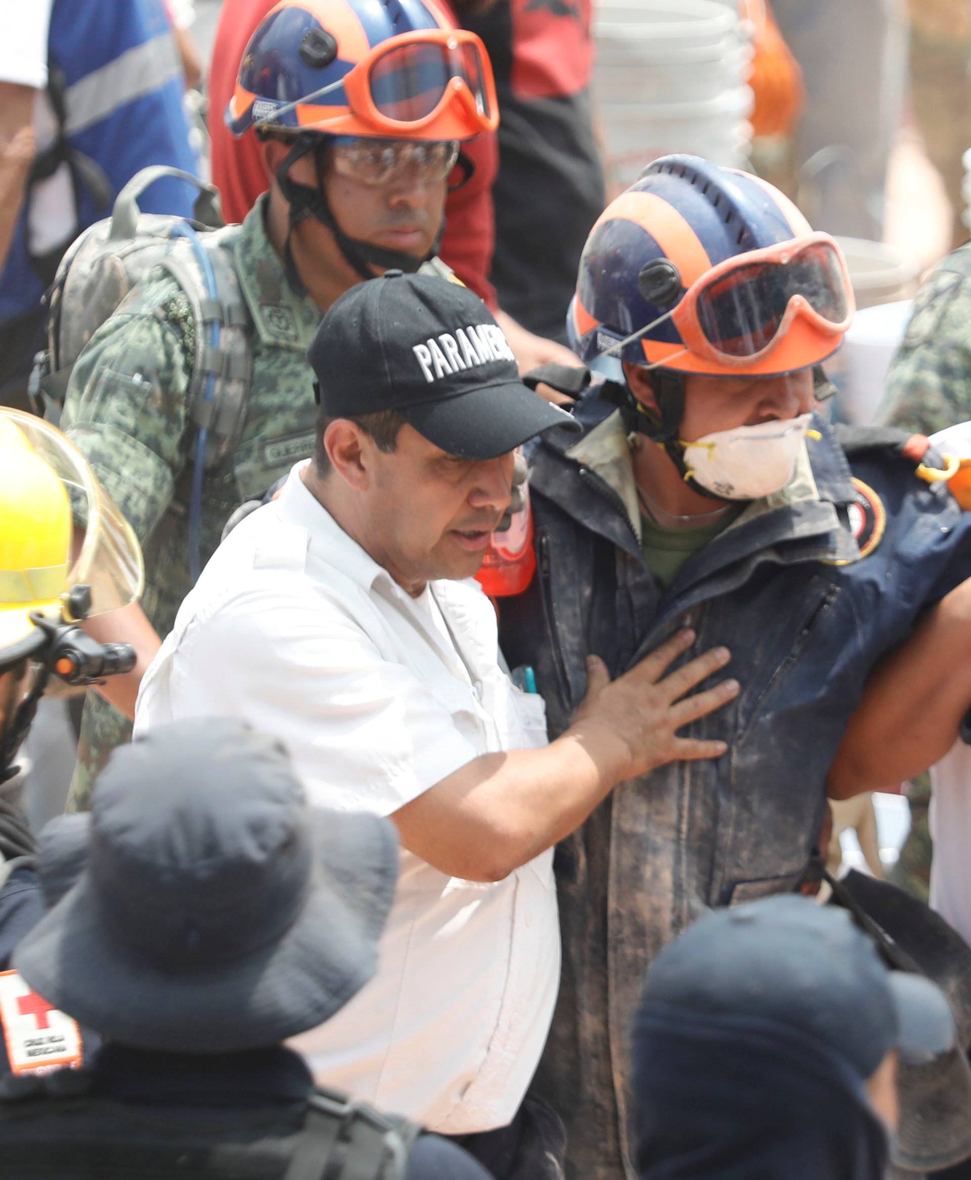 A rescue worker is helped during the search for students at Enrique Rebsamen school after an earthquake in Mexico City