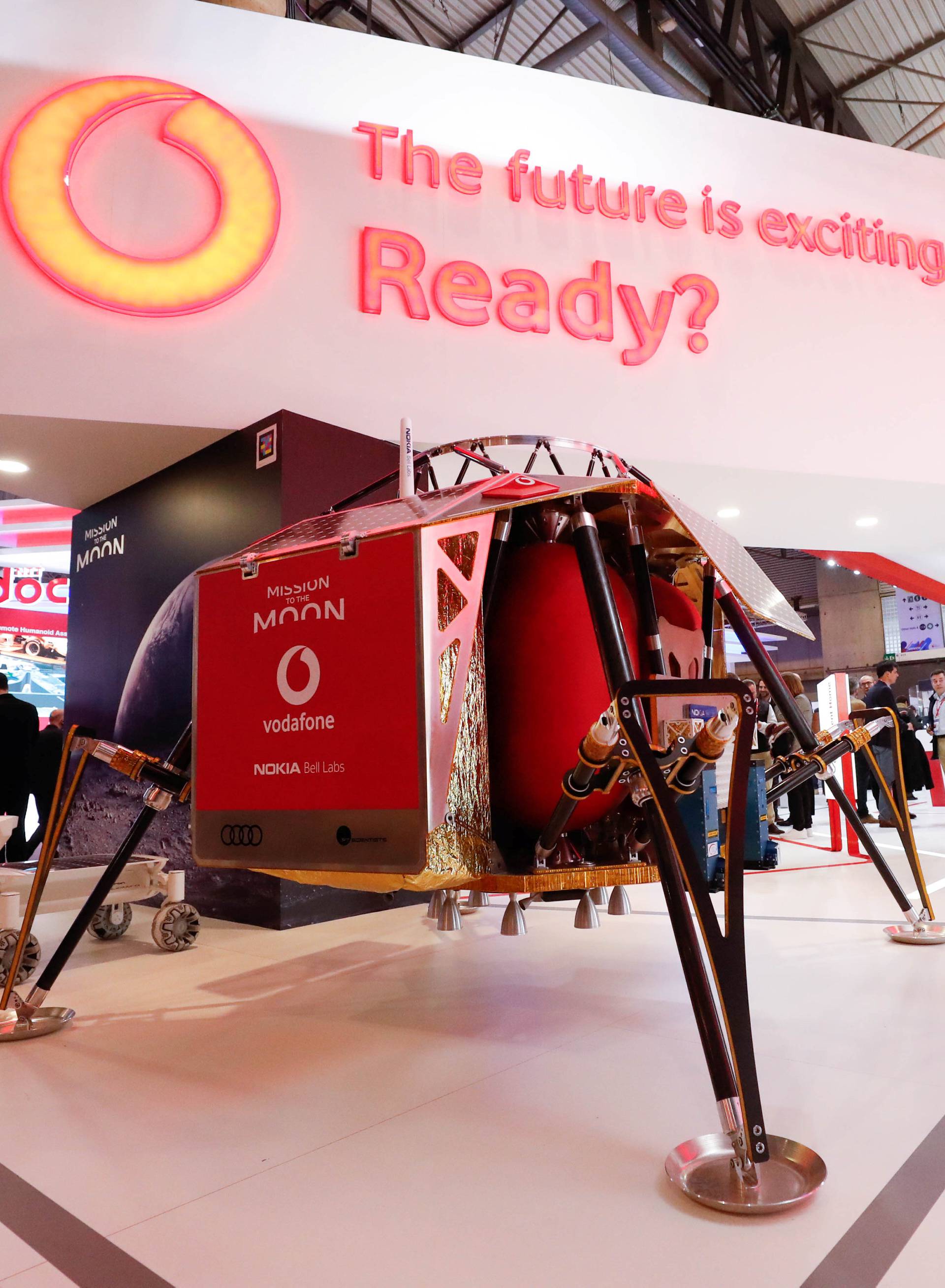 A visitor walks past a mobile mast with an Audi lunar exploration vehicle during the Mobile World Congress in Barcelona