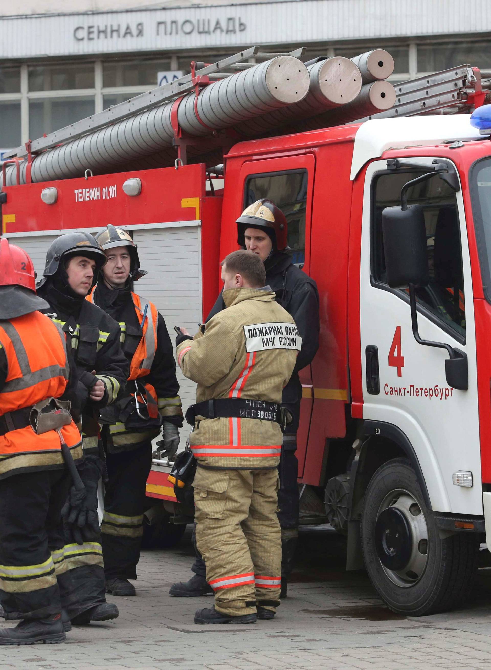 Members of Emergency services stand outside Sennaya Ploshchad metro station in St. Petersburg