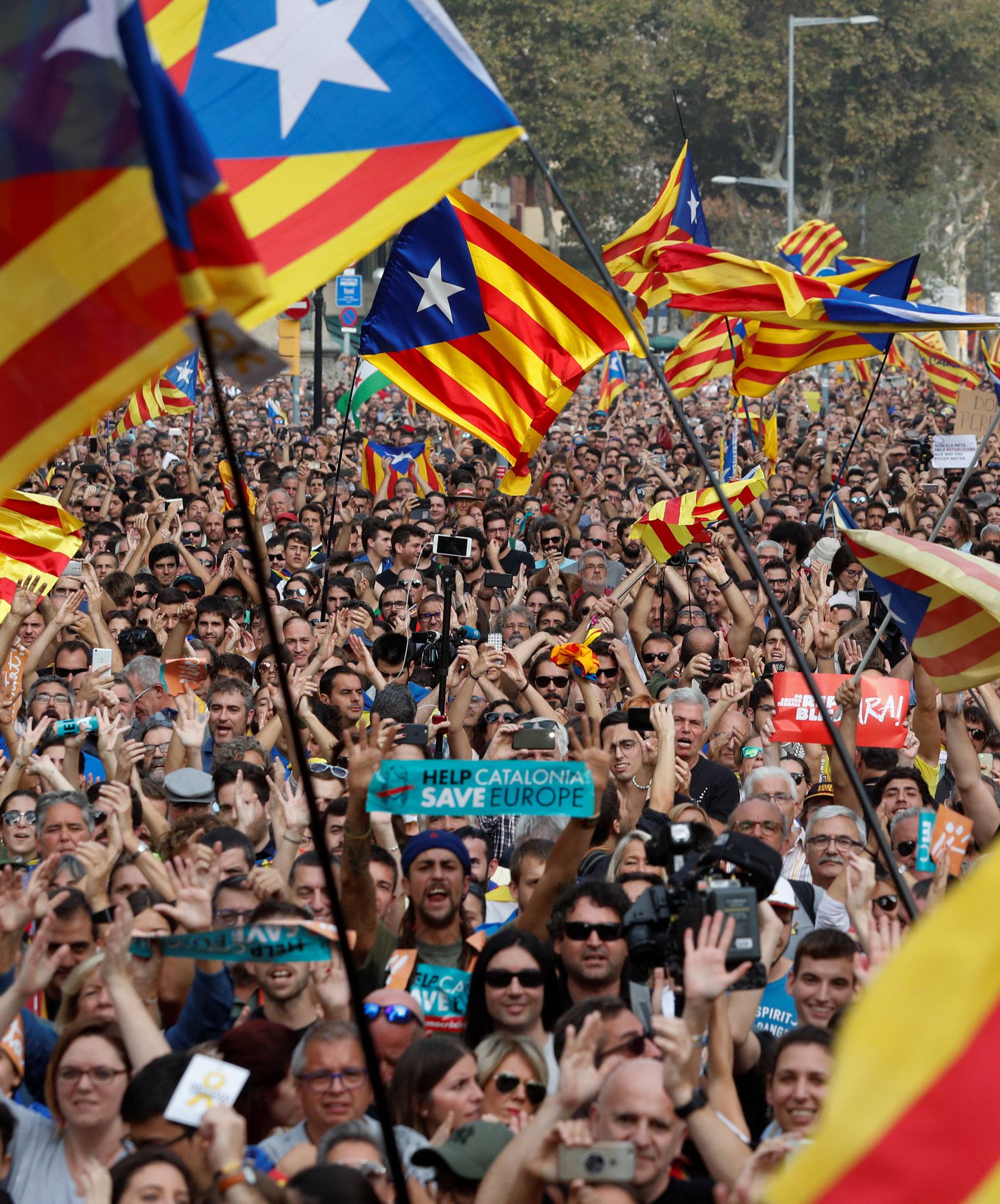 People gather as they watch on giant screens a plenary session outside the Catalan regional parliament in Barcelona