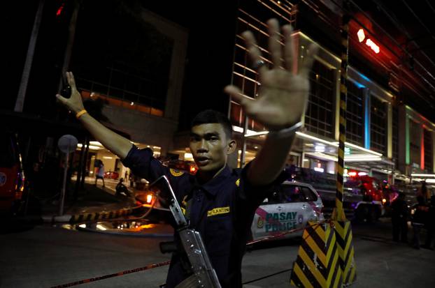 A security guard stops photographers from entering the vicinity of Resorts World Manila after gunshots and explosions were heard in Pasay City, Metro Manila, Philippines