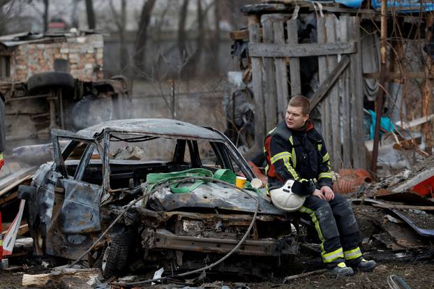 Rescuer rests at a site damaged during a Russian missile strike, in Kyiv