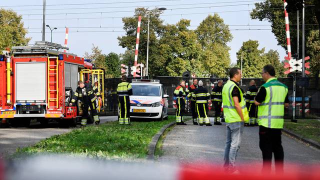 Rescue personnel work at the scene where a train struck a "cargo bicycle" popular with Dutch parents to transport their children at the city of Oss