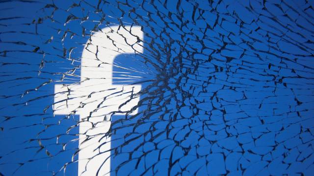 FILE PHOTO: Facebook logo is displayed through broken glass in this illustration