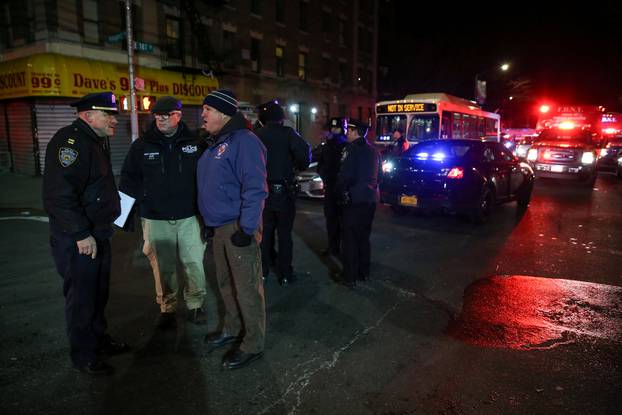 NYPD officers stand guard during an evacuation following a fire at an apartment building in New York