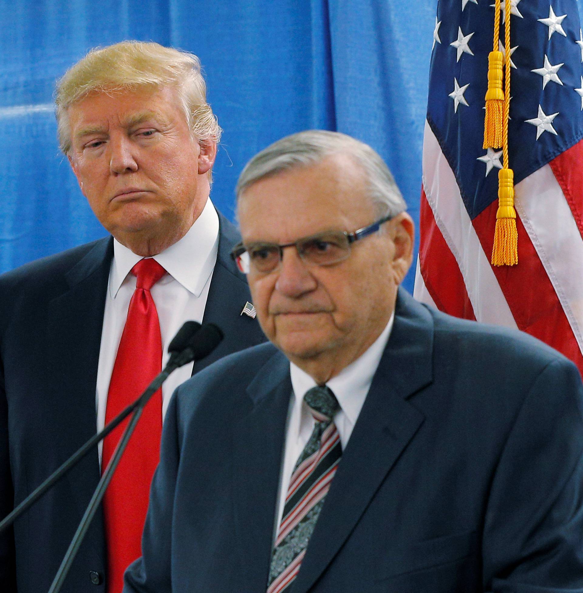 FILE PHOTO: U.S. Republican presidential candidate Donald Trump listens as Maricopa County Sheriff Joe Arpaio speaks to reporters before a campaign rally in Marshalltown