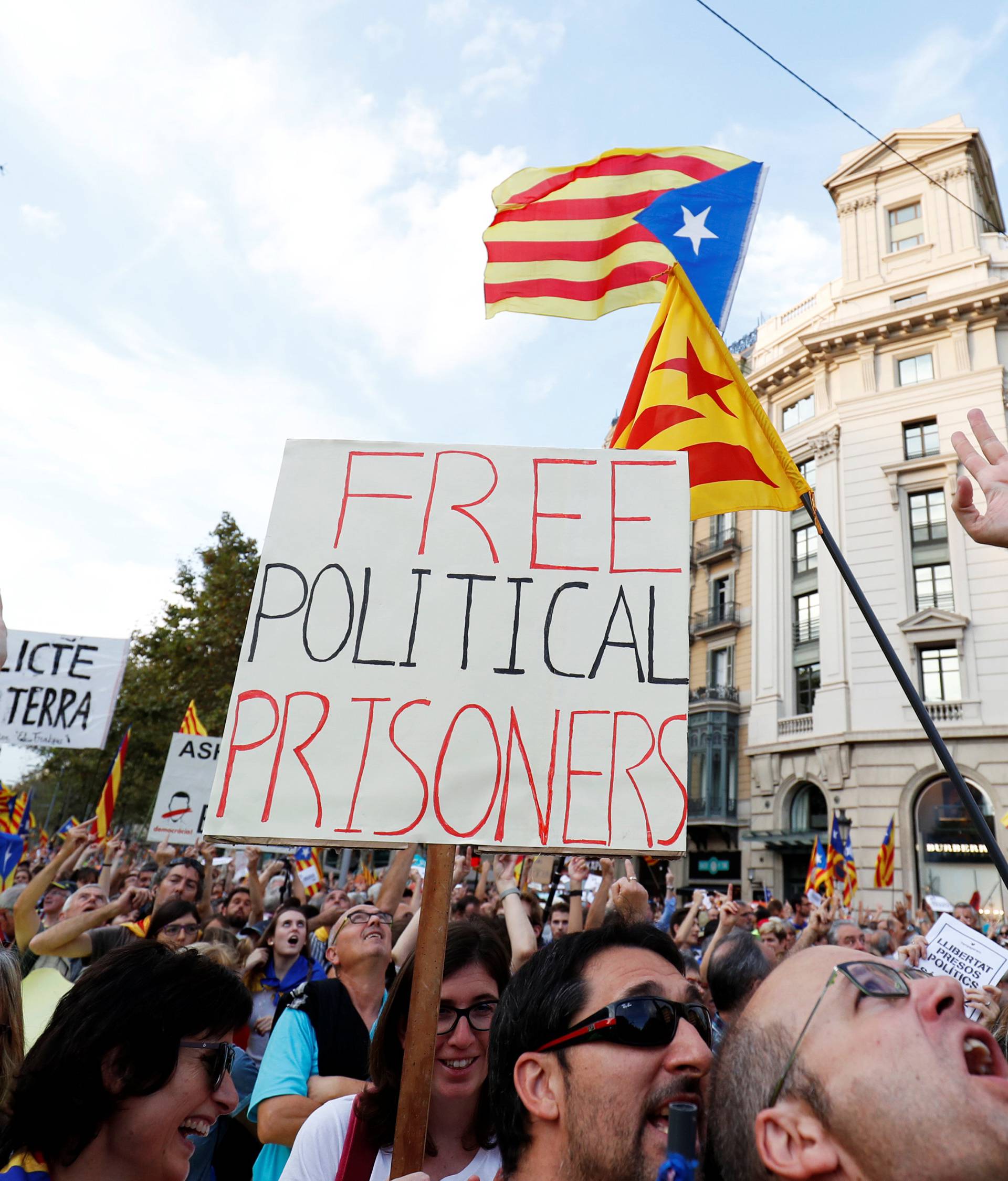 People wave placards and separatist Catalan flags during a demonstration organised by Catalan pro-independence movements ANC (Catalan National Assembly) and Omnium Cutural, following the imprisonment of their two leaders, in