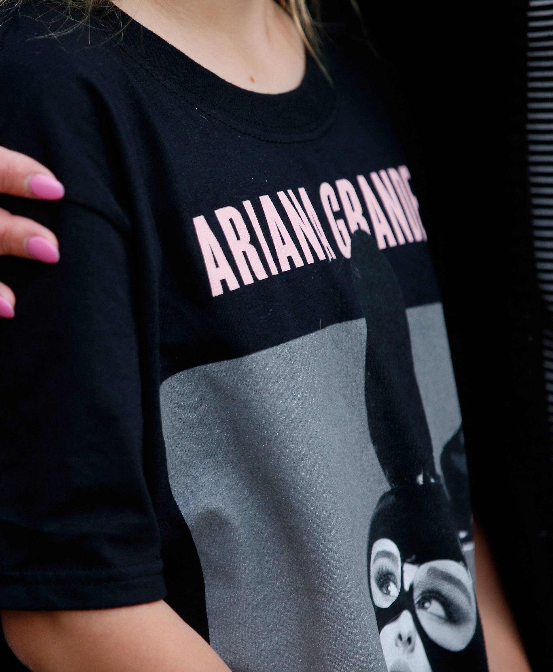 A youngster wearing a t-shirt showing U.S. singer Ariana Grande talks to the media near the Manchester Arena in Manchester