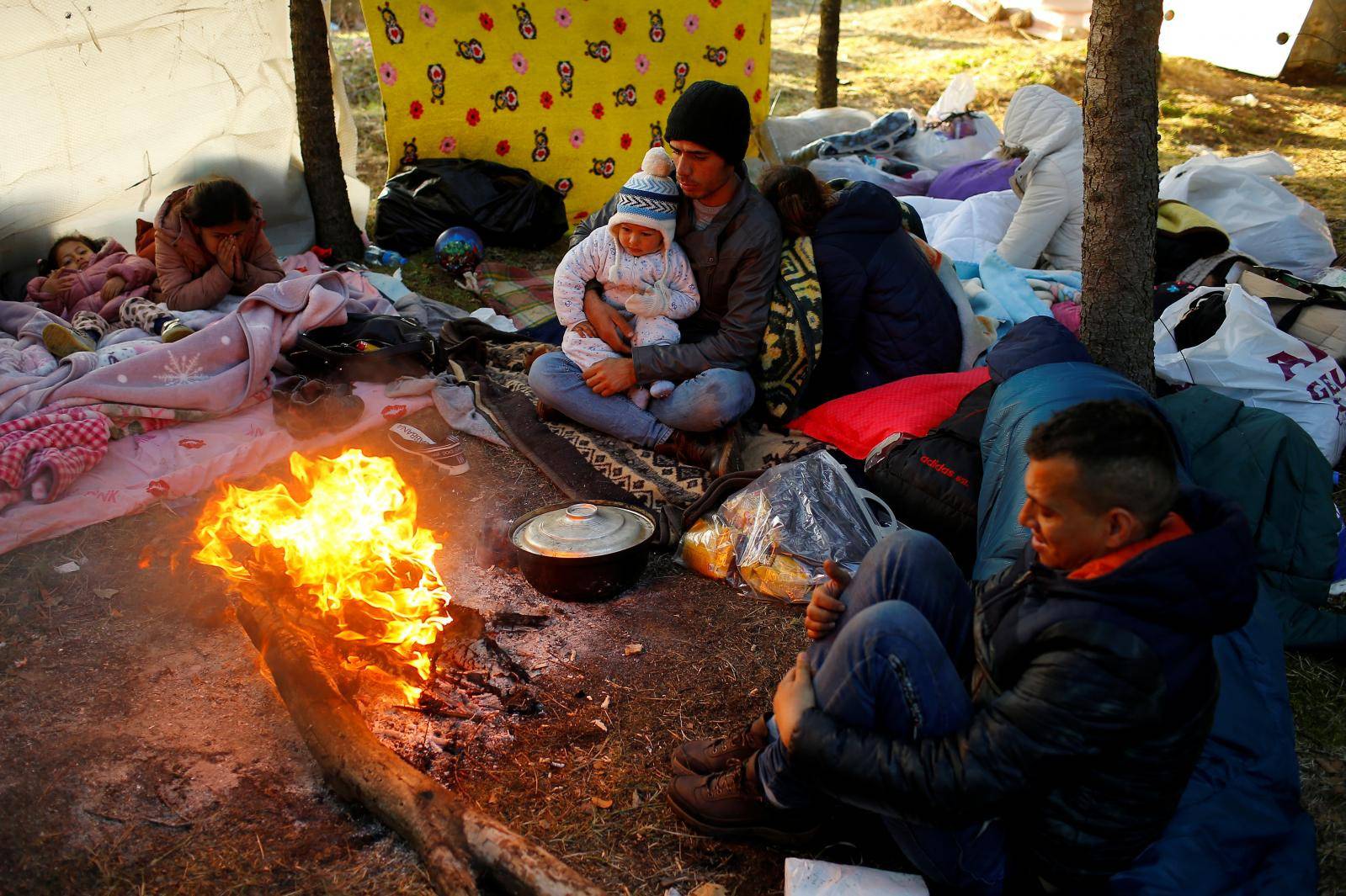 Migrants rest near Turkey's Pazarkule border crossing with Greece's Kastanies, near Edirne