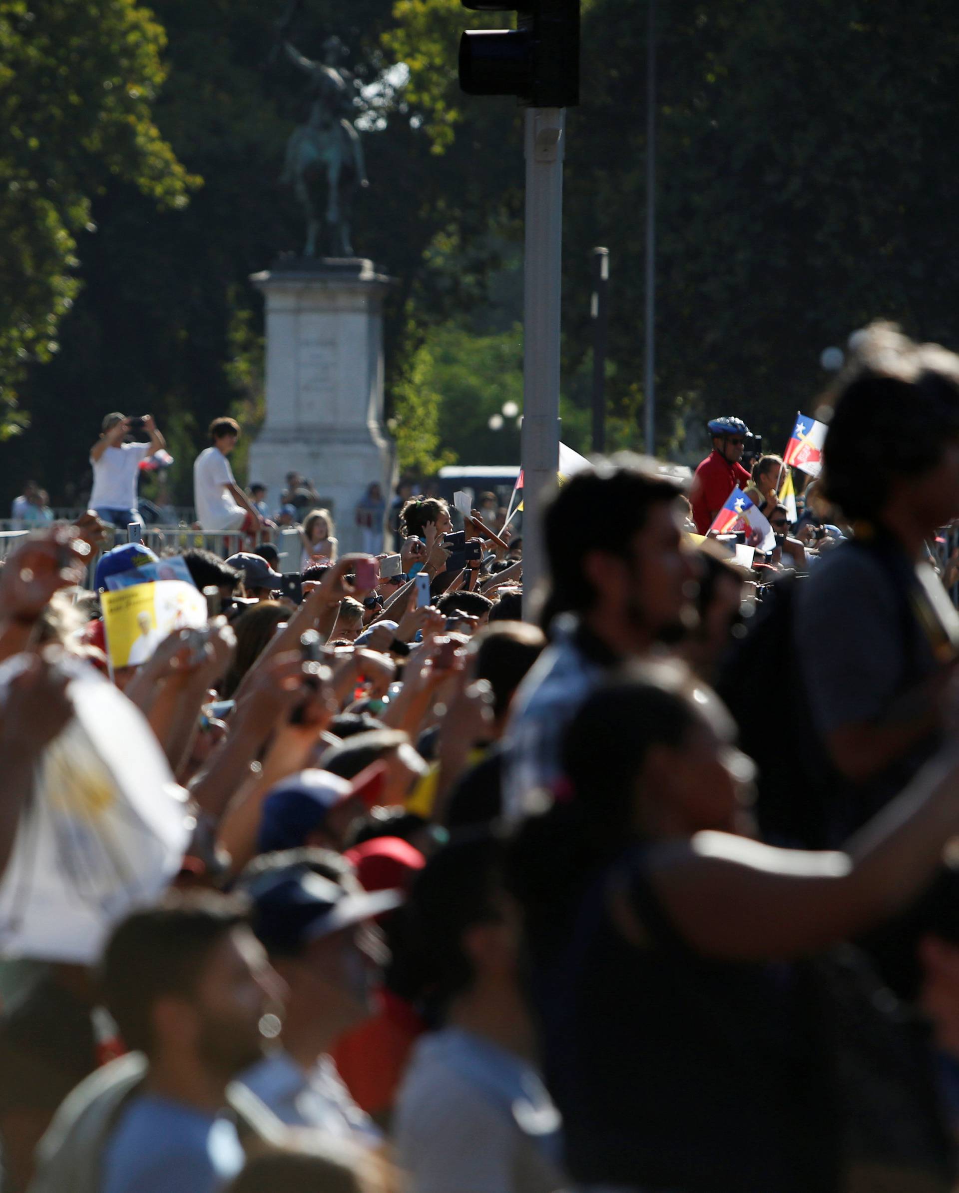 People wait for Pope Francis to drive past, in Santiago