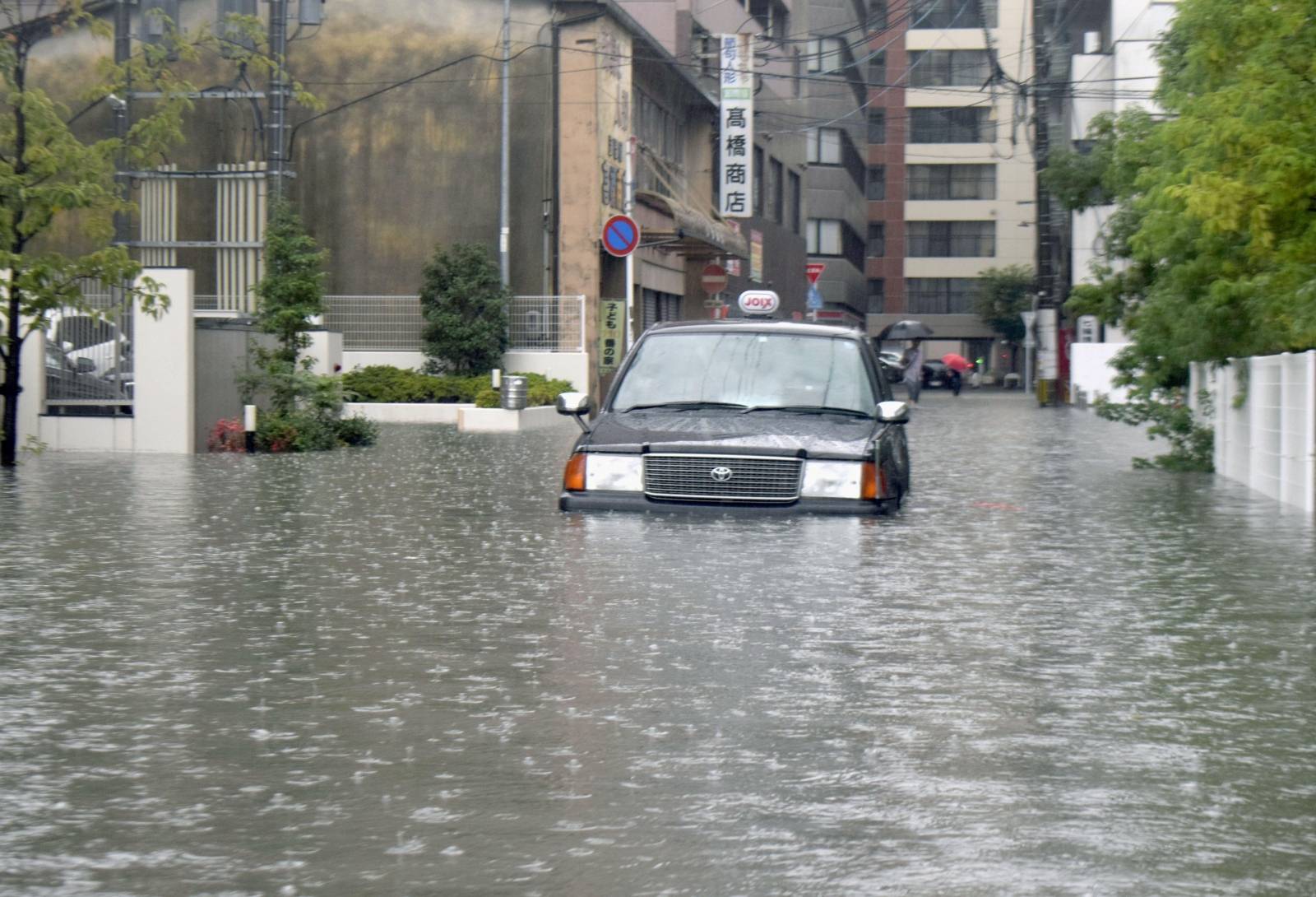 A taxi is stuck in floodwaters caused by heavy rain, in Saga, Saga prefecture, southern Japan