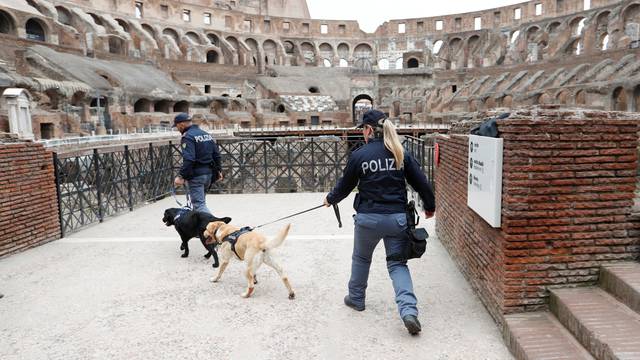 Security patrol with dogs inside the Colosseum before the Via Crucis (Way of the Cross) procession during Good Friday celebrations in Rome