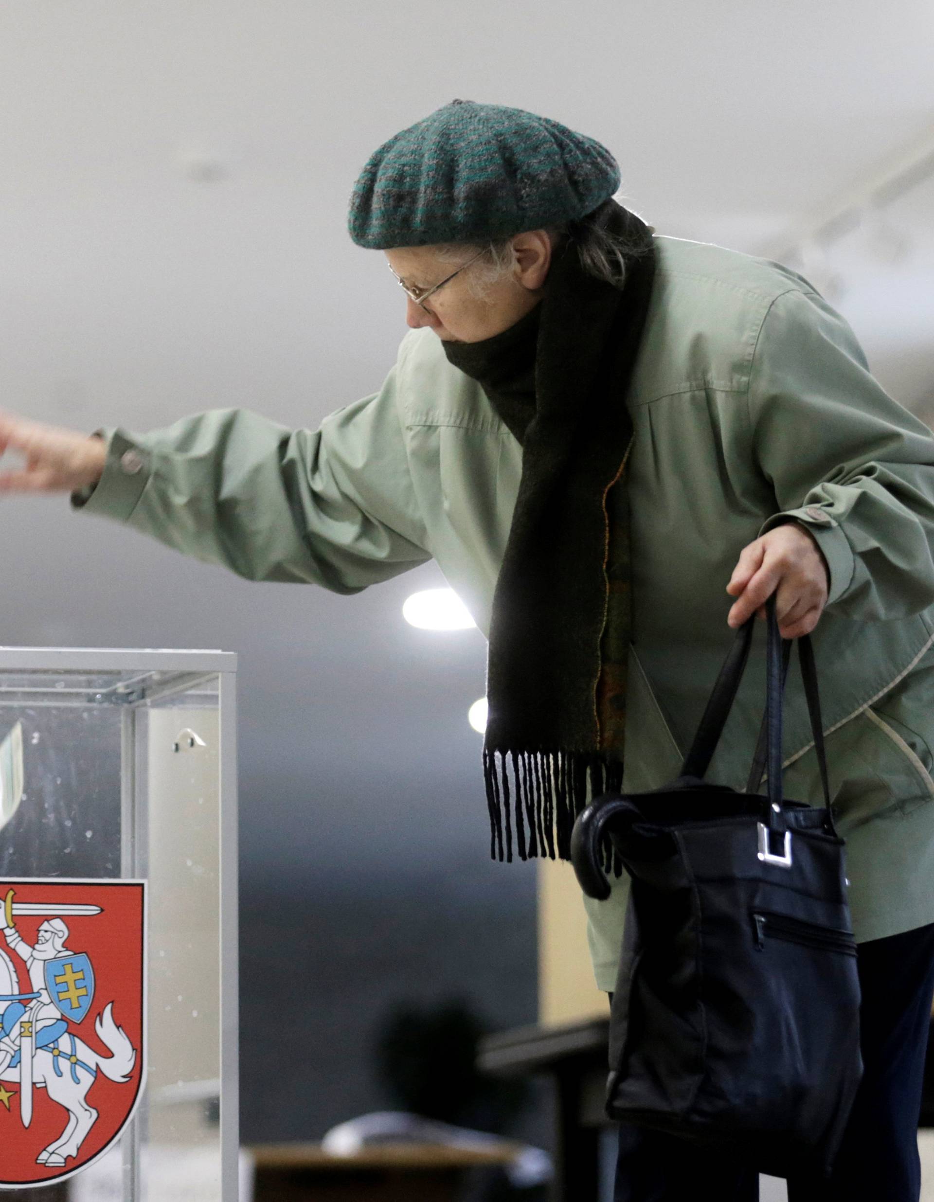 A woman casts her vote during a general election run-off in Birzai