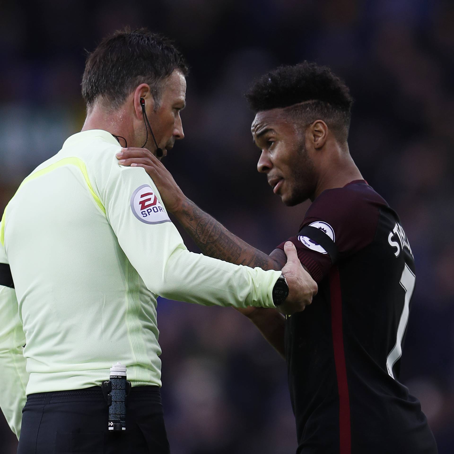 Manchester City's Raheem Sterling speaks with referee Mark Clattenburg at half time