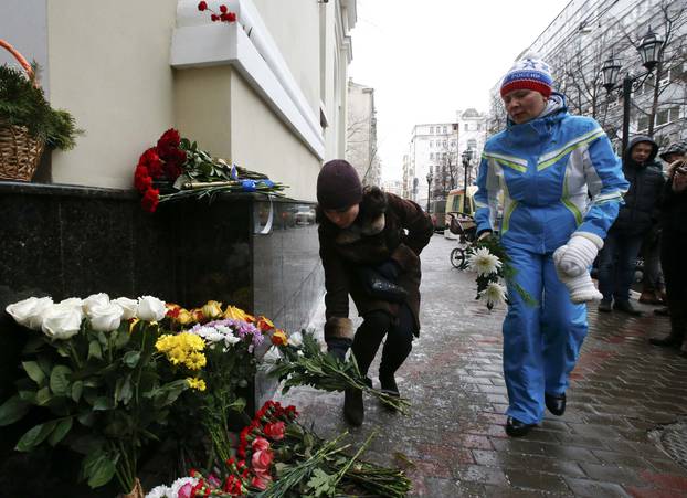 People lay flowers in memory of passengers and crew members of Russian military Tu-154 plane crashed into Black Sea, outside headquarters of Red Army Choir in Moscow