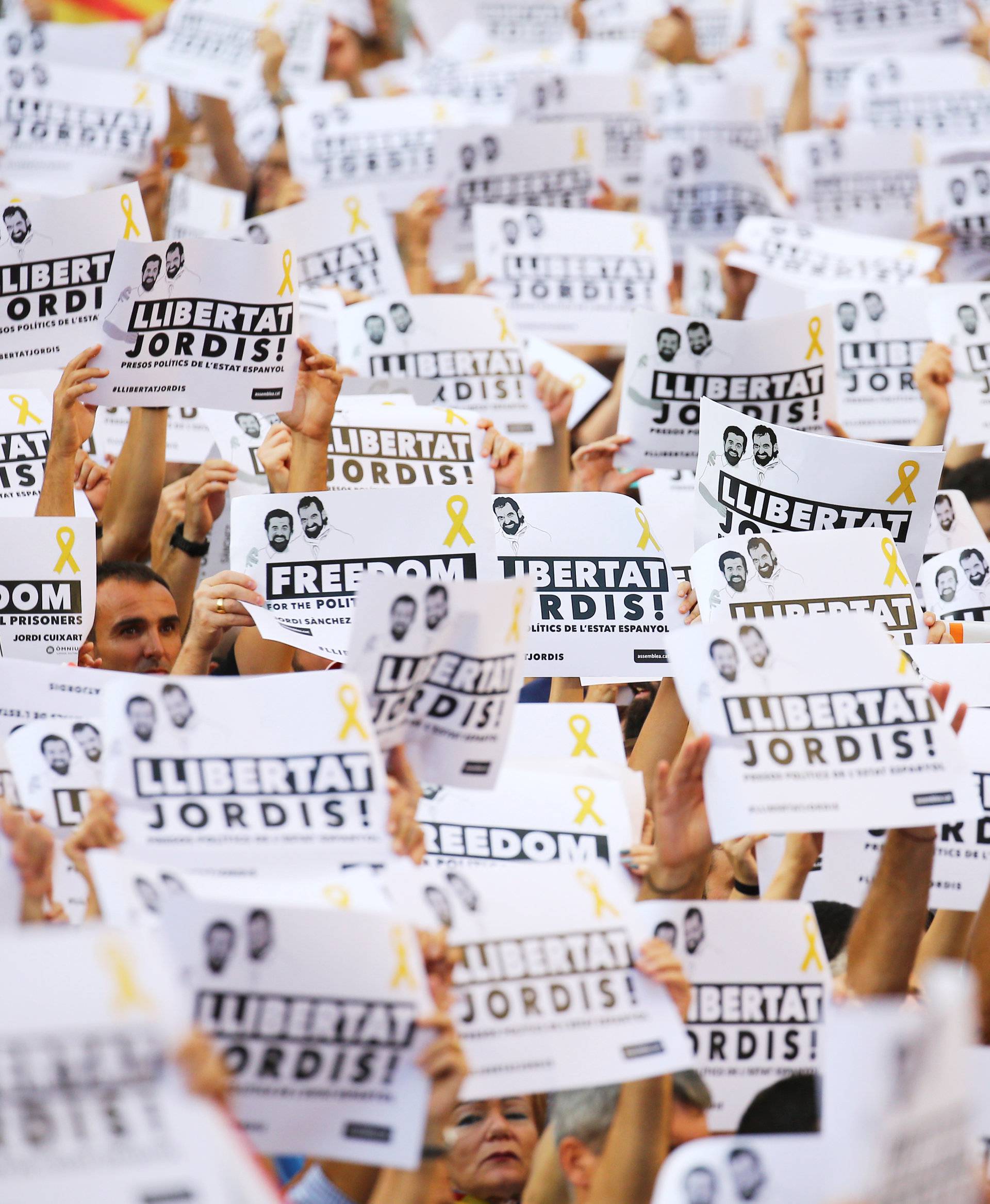 People wave placards which read "Freedom for the Jordis" in Catalan during a demonstration organised by Catalan pro-independence movements ANC (Catalan National Assembly) and Omnium Cutural, following the imprisonment of their two leaders in Barcelona