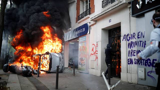 Car burns outside Renault automobile garage during May Day clashes in Paris