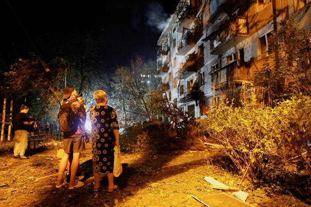 Firefighters work at the site of an apartment building hit by a Russian missile strike in Kyiv